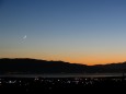 The moon is in the western sky as the sun sets in Utah Valley.